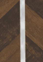 A thin white vertical strip placed against a textured brown wood background.