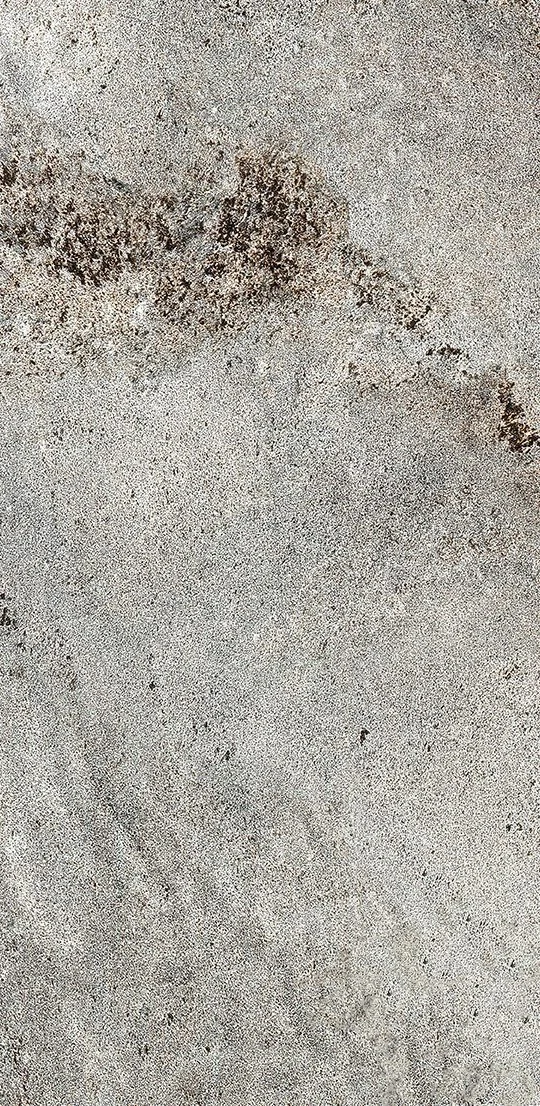 Grey concrete texture with dark brown weathered patches and a grainy surface.